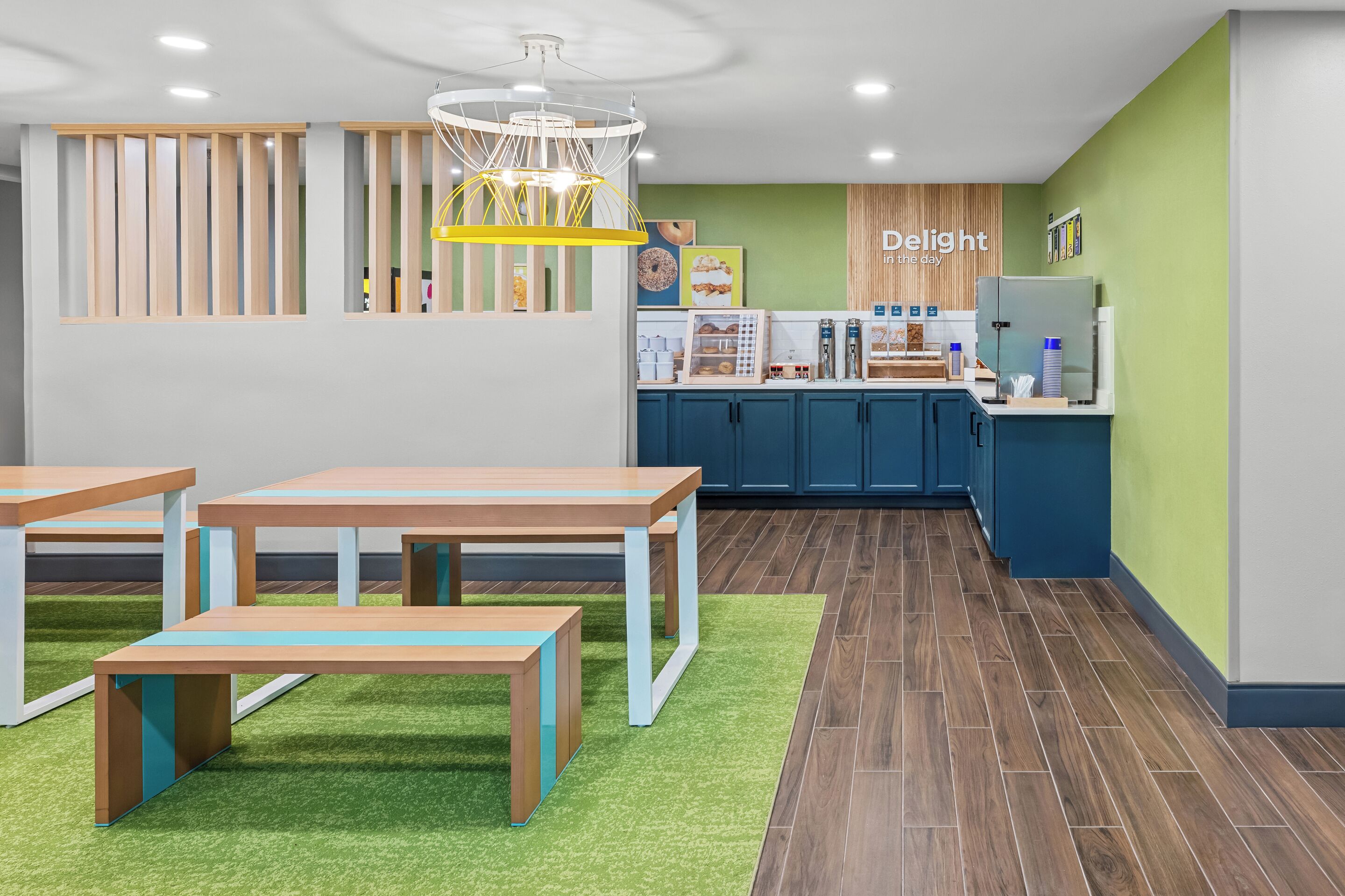 A modern interior with tables, a counter, and a green wall.