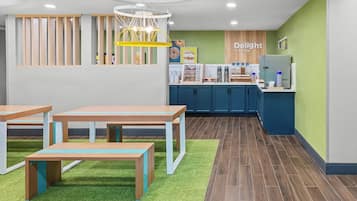 A modern interior with tables, a counter, and a green wall.