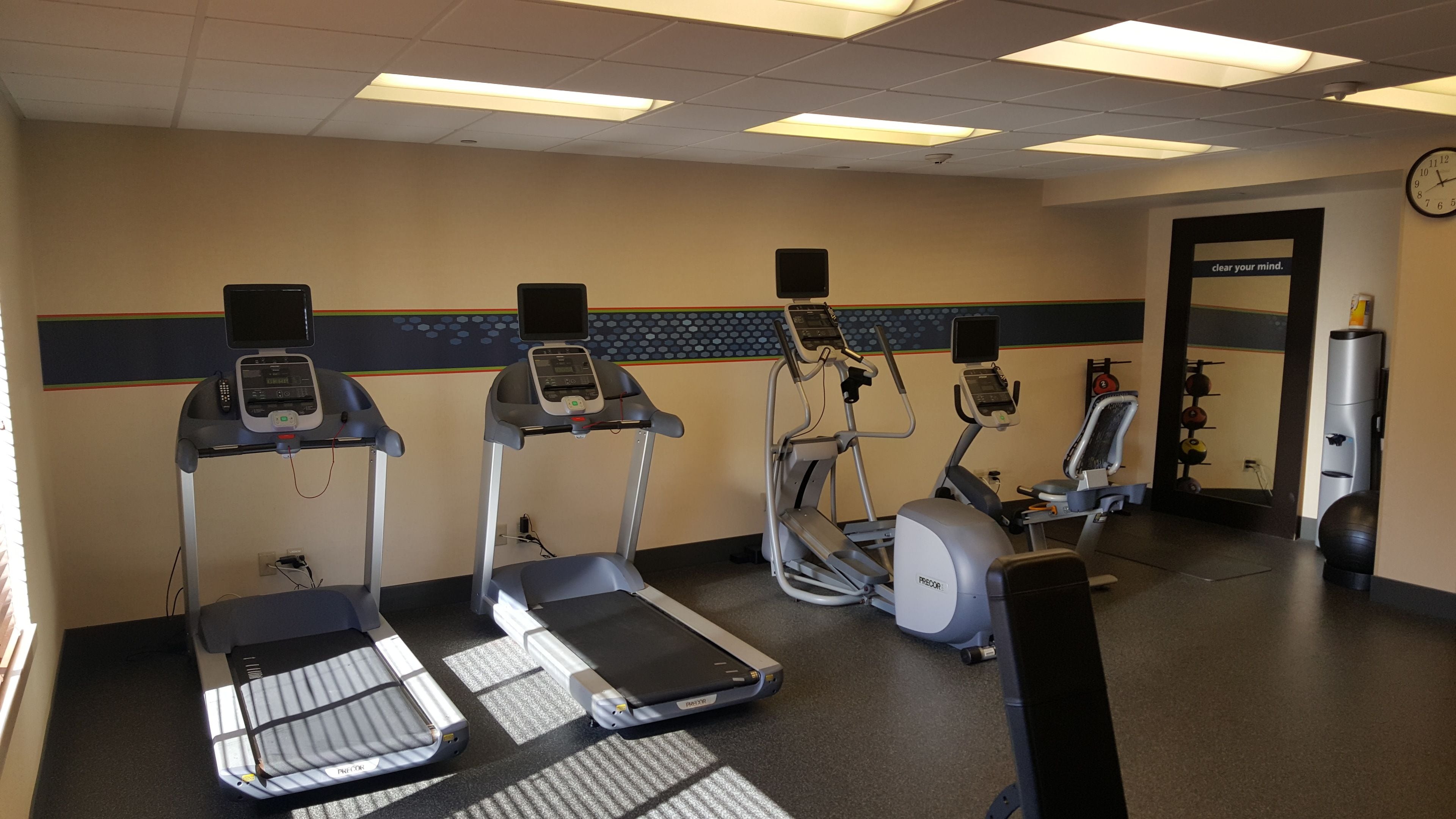 A gym with treadmills, an elliptical, and a stationary bike.