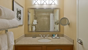 Une salle de bain avec un lavabo, un miroir, un porte-serviettes et un tableau encadré au mur.