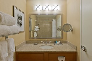 A bathroom with a sink, mirror, towel rack, and a framed picture on the wall. - Crowne Plaza Albuquerque by IHG (Albuquerque)