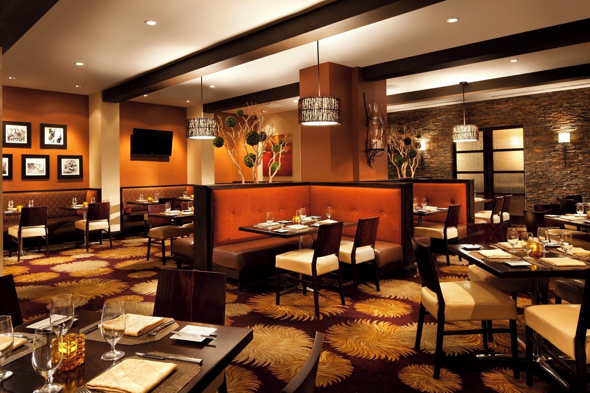 Un restaurant avec des banquettes, des tables et une moquette à motifs.