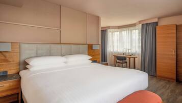 Ein Hotelzimmer mit einem großen Bett, einem Schreibtisch und einem Kleiderschrank.