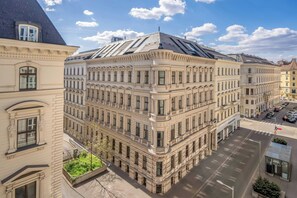 A multi-story building with classical architecture, featuring a prominent corner entrance and large windows.