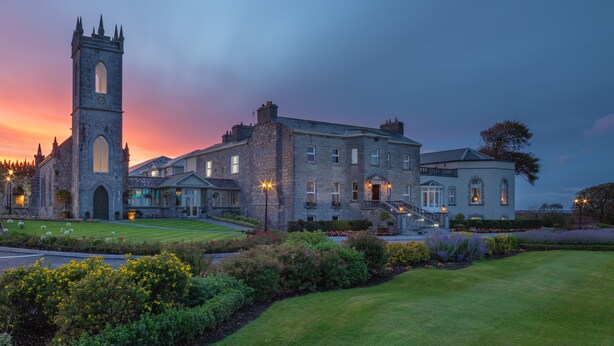 A historic building with a prominent tower and a well-maintained lawn. - Glenlo Abbey Hotel (Galway)