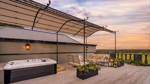 A rooftop patio with a hot tub, seating area, and a view of the landscape. - Glenlo Abbey Hotel (Galway)
