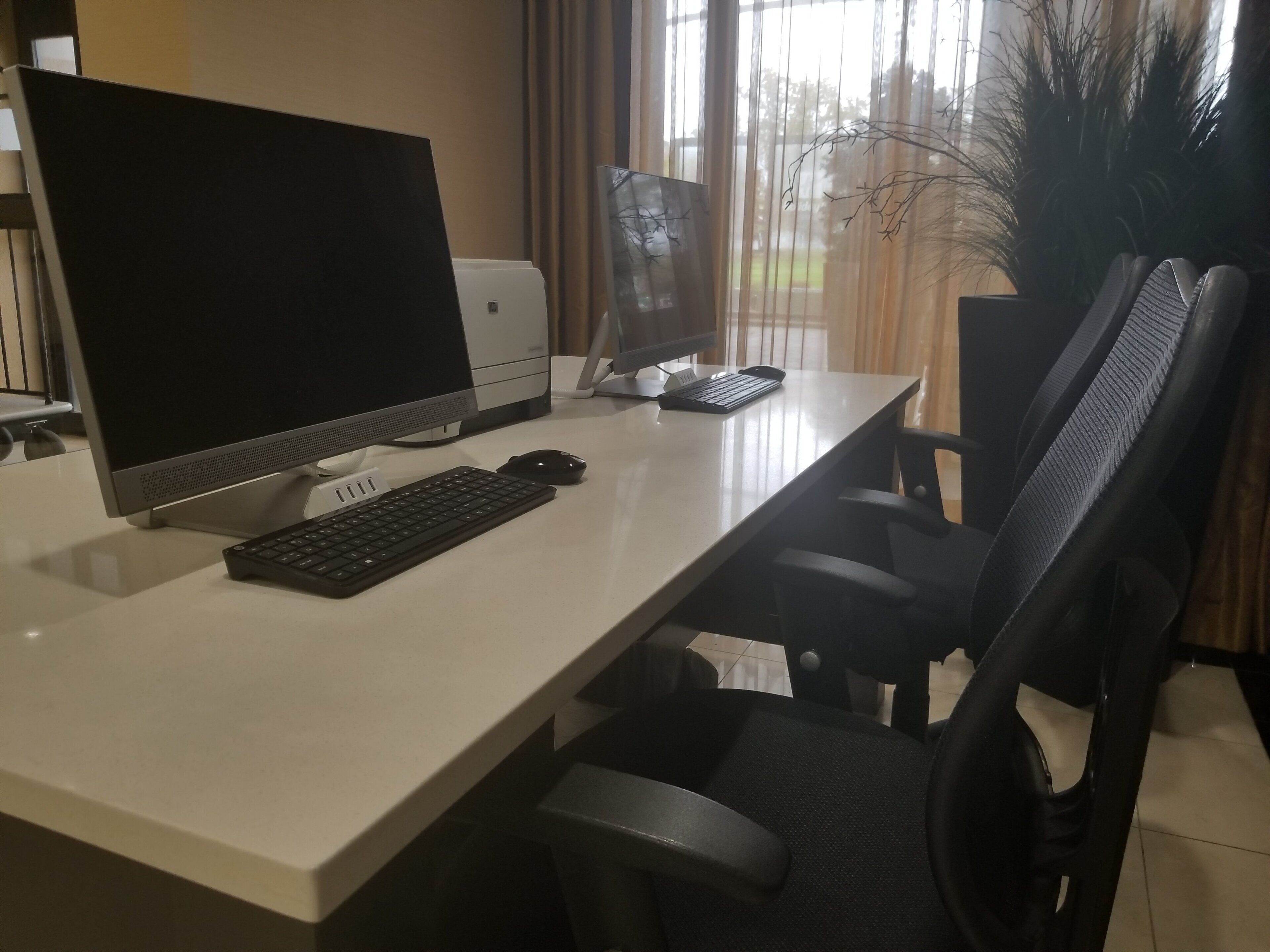 Un bureau moderne, équipé d’un ordinateur de bureau, d’un clavier, d’une souris et d’une chaise.