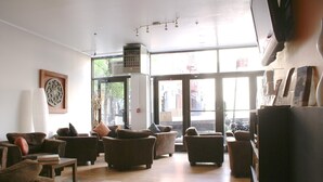 A spacious lobby with multiple sofas and armchairs arranged for seating. - Off Soho Suites Hotel (New York)