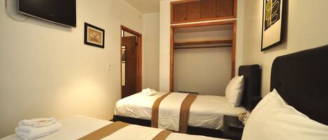 A hotel room with two beds, a TV mounted on the wall, a wooden closet, and a framed picture on the wall.