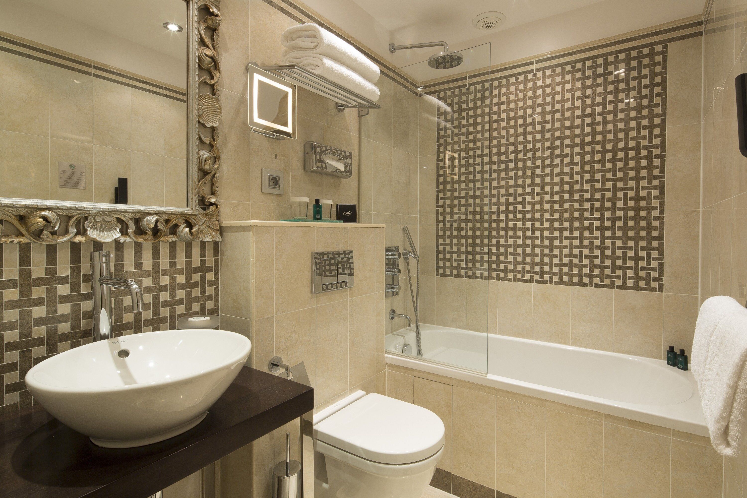 A modern bathroom with a large sink, toilet, and bathtub.
