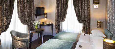 Una habitación de hotel con cama, sillón, escritorio y televisor.