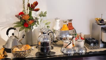 Montaje de un bufé de desayuno con diversos alimentos, bebidas y elementos decorativos.