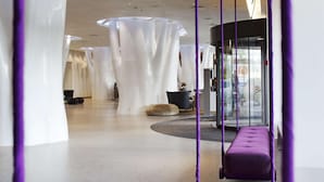 A modern lobby with a central seating area, a glass entrance, and a view of the outside. - Scandic Copenhagen (Copenhagen)