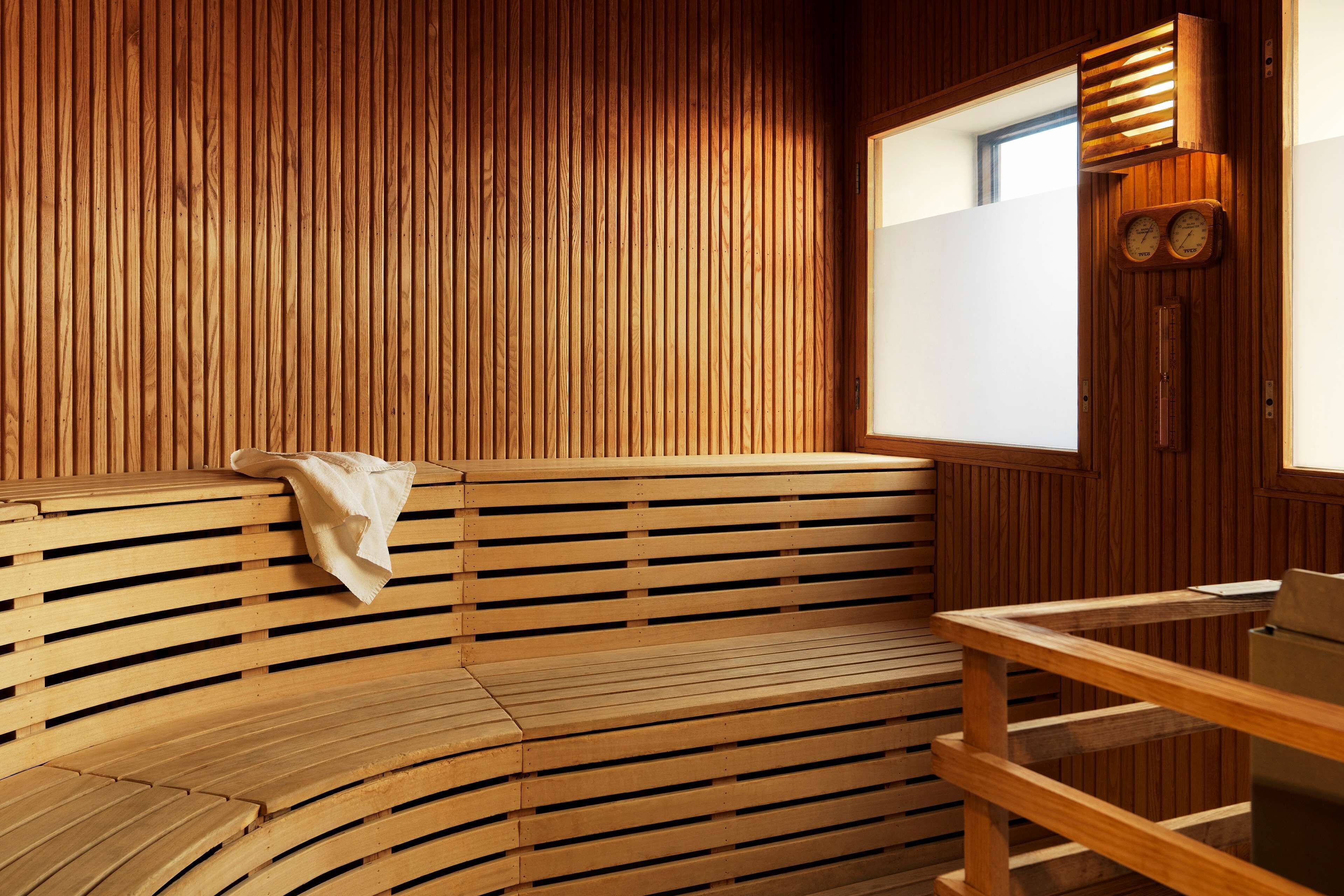 A wooden sauna with benches and a wooden table.