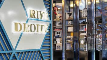 A modern interior with a prominent 'RIVERE DROITA' sign, a library section, and a variety of displayed items.