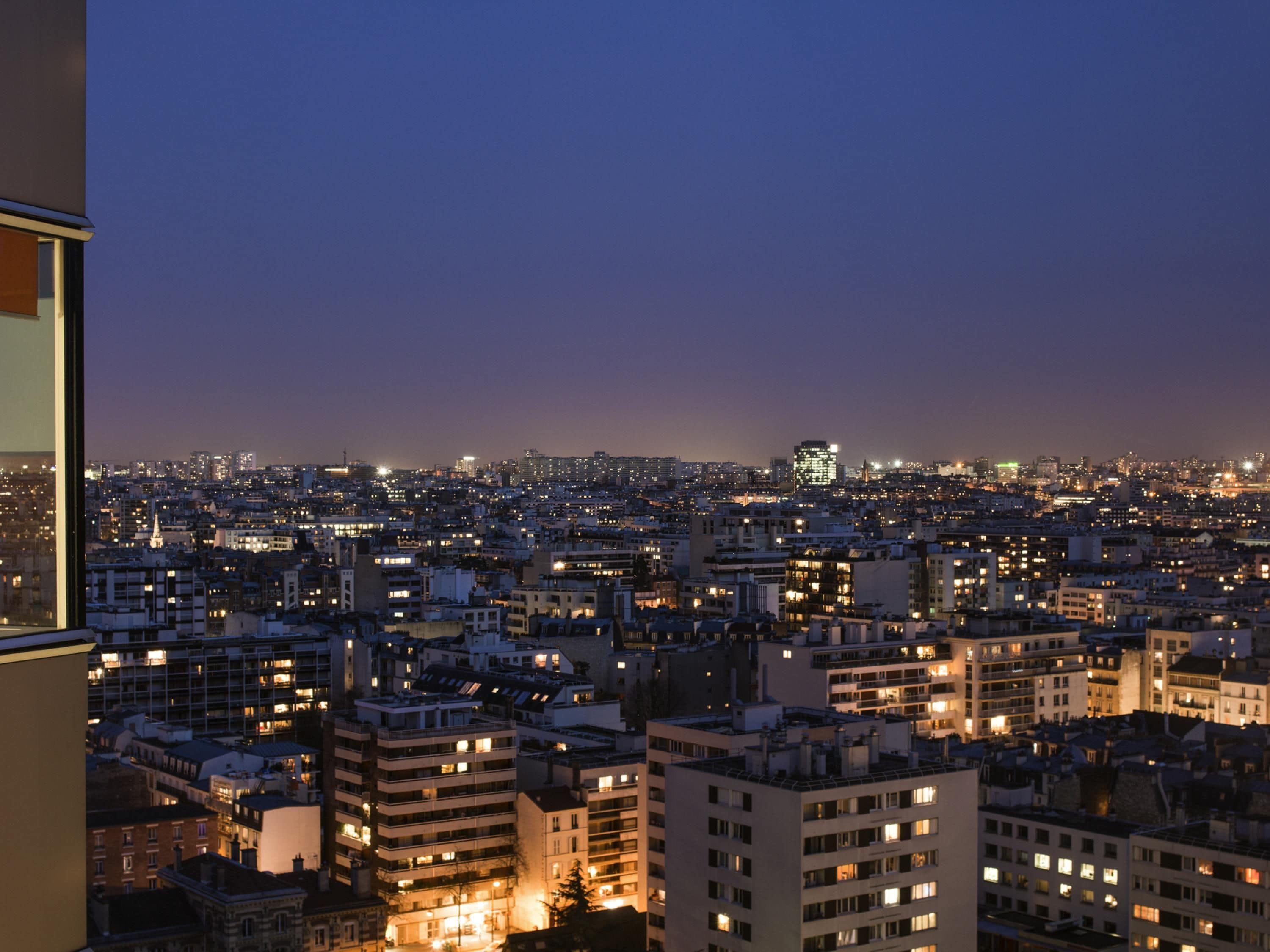Un horizonte urbano al anochecer, con edificios iluminados y vistas al perfil de la ciudad.
