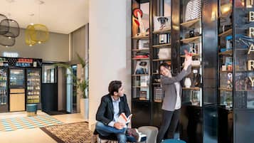 Un intérieur moderne comprenant un espace boutique, une bibliothèque et un coin salon.