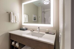 A modern bathroom with a large mirror, a sink, and a shower. - La Quinta Inn & Suites by Wyndham Middletown-Goshen (Middletown)