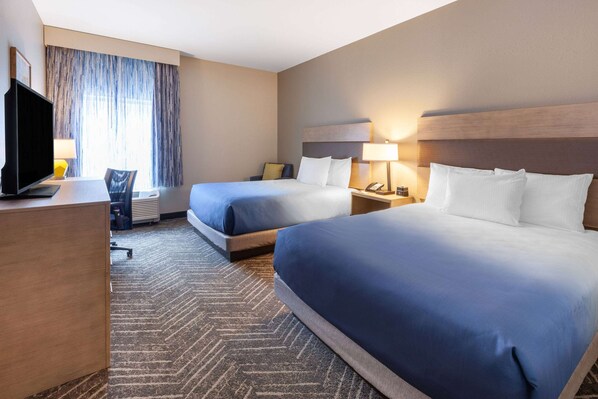 A hotel room with two beds, a desk, a TV, and a chair. - La Quinta Inn & Suites by Wyndham Middletown-Goshen (Middletown)