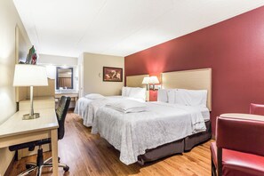 A hotel room with two beds, a desk, a chair, and a red armchair. - Red Roof Inn PLUS+ Nashville North - Goodlettsville (Goodlettsville)