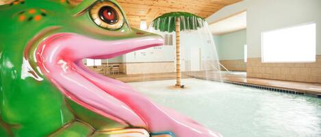 A large indoor pool with a wooden ceiling and a decorative frog statue.