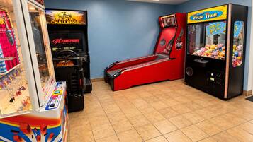 A gaming arcade with various machines, including a claw machine and racing games.