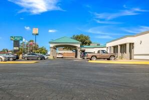 A parking lot with a building entrance, a Budget Inn sign, and a Quality Inn sign.
