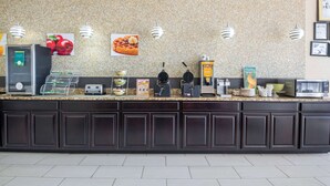 Una encimera de cocina con cafetera, tostadora, máquina para gofres y un letrero que dice 'Healthy'.