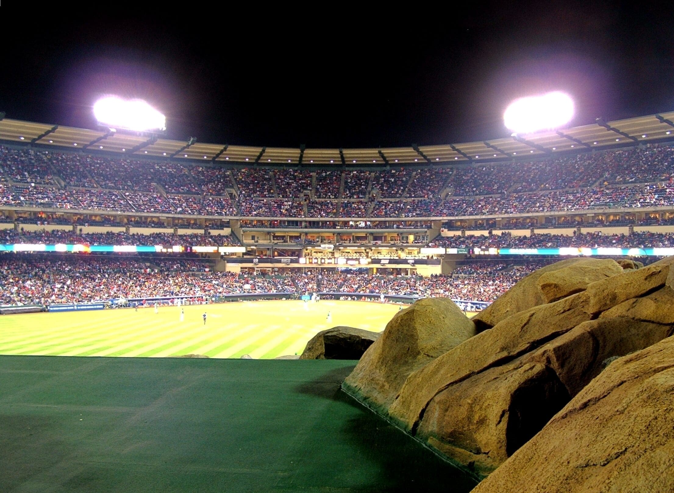 A large stadium with multiple tiers of seating and a well-lit field.