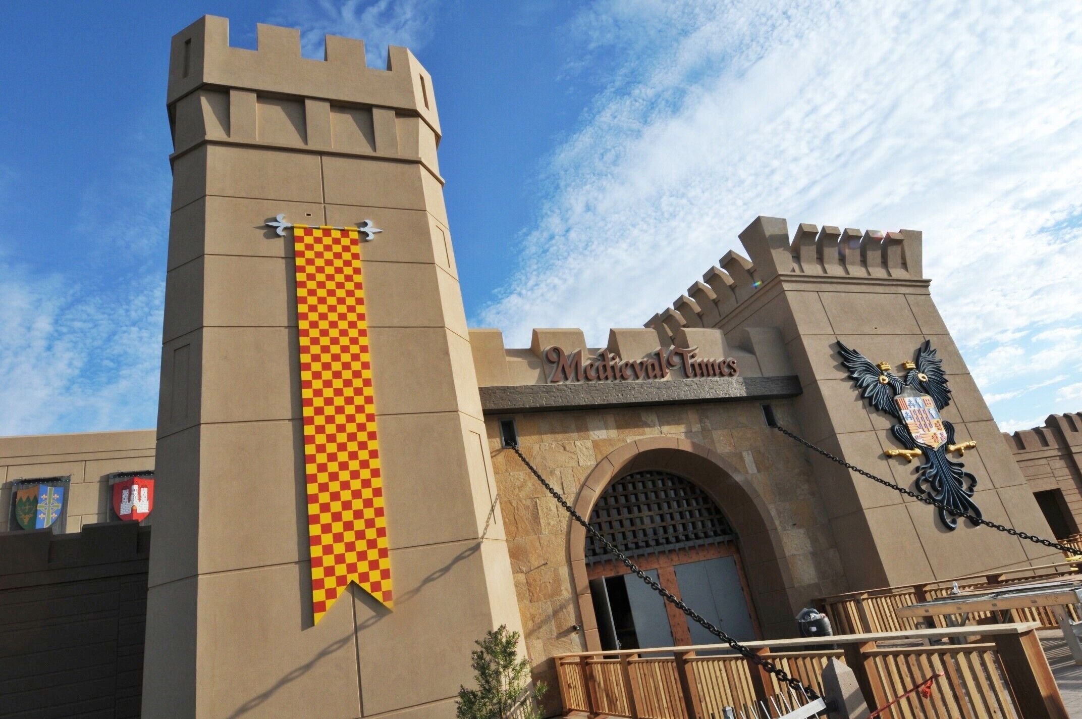 A castle-like entrance with a checkered banner and a coat of arms.