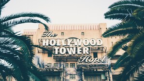 El Hotel Hollywood Tower con un letrero llamativo, rodeado de palmeras.