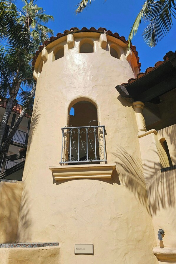 A building with a balcony, a small window, and a sign indicating a 'Ballroom'. - The Buena Park Grand Hotel & Suites (Buena Park)