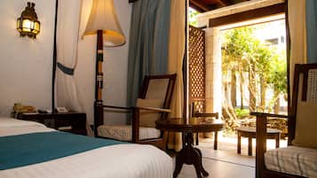 Une chambre d’hôtel avec un lit, un bureau doté d’une lampe, une chaise et une petite table.