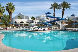 A swimming pool with a water slide, lounge chairs, palm trees, and a building with arches. - The Westin Rancho Mirage Golf Resort & Spa (Rancho Mirage)