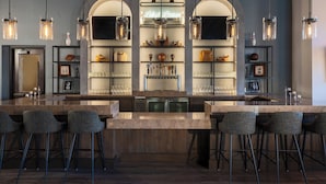 A bar area with a long counter, bar stools, and shelves with glasses and bottles. - The Westin Rancho Mirage Golf Resort & Spa (Rancho Mirage)