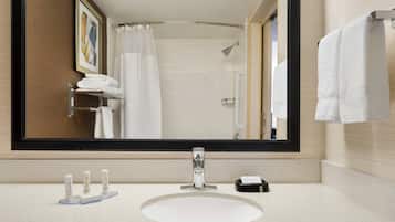 Un baño moderno con un espejo grande, un lavabo redondo y una zona de ducha.