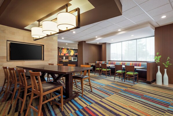 A conference room with a large table, chairs, a projector screen, and a colorful carpet. - Fairfield Inn by Marriott Philadelphia West Chester/Exton (Exton)