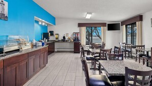 A hotel dining area with a buffet, seating, and a TV mounted on the wall. - Days Inn by Wyndham Fond du Lac (Fond du Lac)
