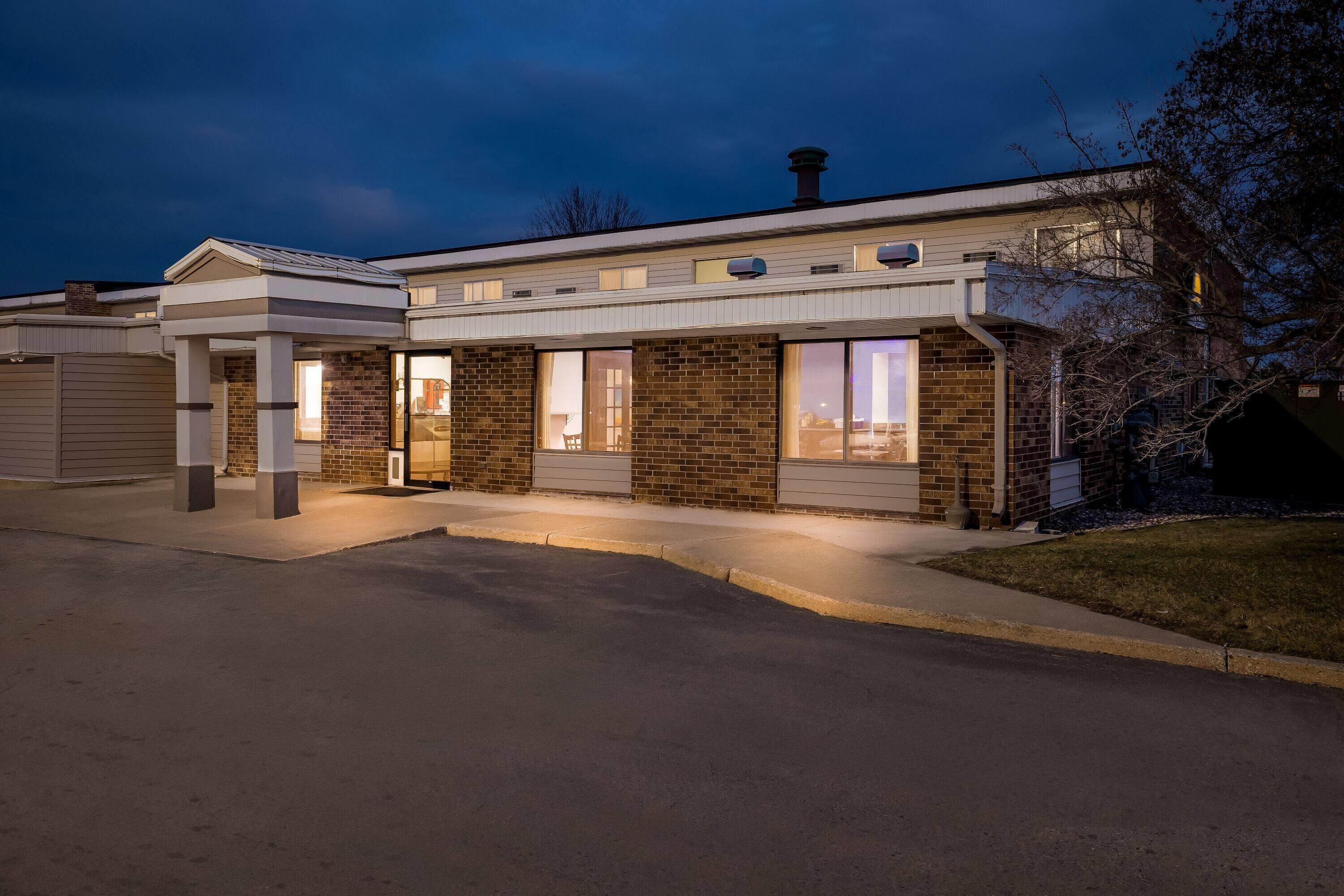 A modern building with a flat roof, large windows, and a garage entrance.