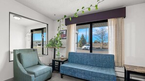 A modern living room with a sofa, armchair, and a small table. - Days Inn by Wyndham Fond du Lac (Fond du Lac)