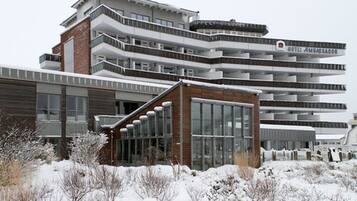 Ein mehrstöckiges Hotel mit modernem architektonischen Design, das Balkone und große Fenster aufweist.