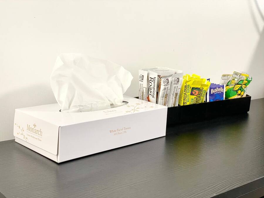A tissue box and a tray of snacks on a table.