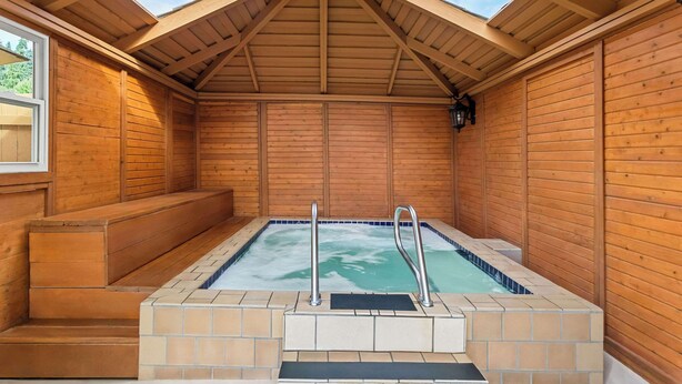 A wooden spa room with a hot tub, wooden steps, and a skylight. - Quality Inn & Suites Vancouver - Hazel Dell (Vancouver)
