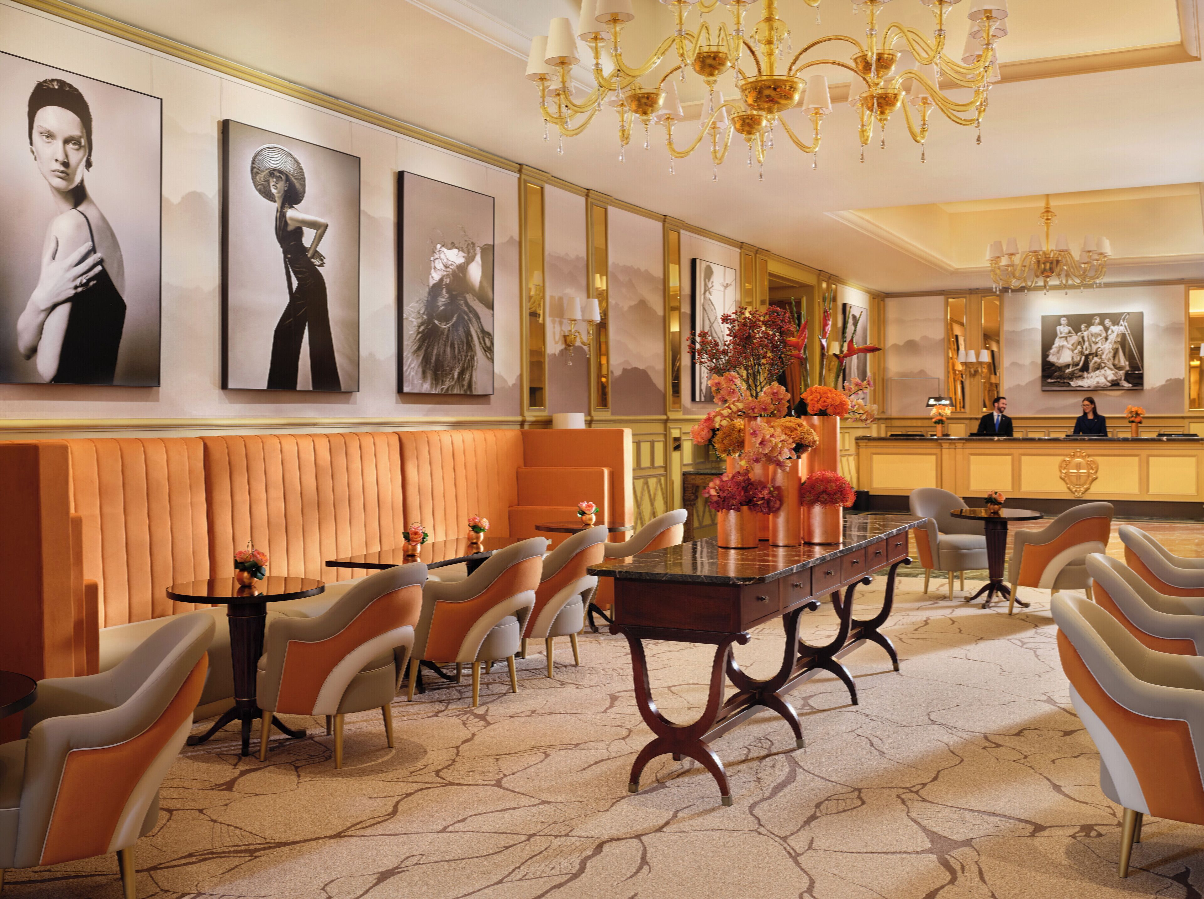 Een hotel lobby met een receptiebalie, een zithoek en kunstwerken aan de wanden.