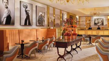 Een hotel lobby met een receptiebalie, een zithoek en kunstwerken aan de wanden.