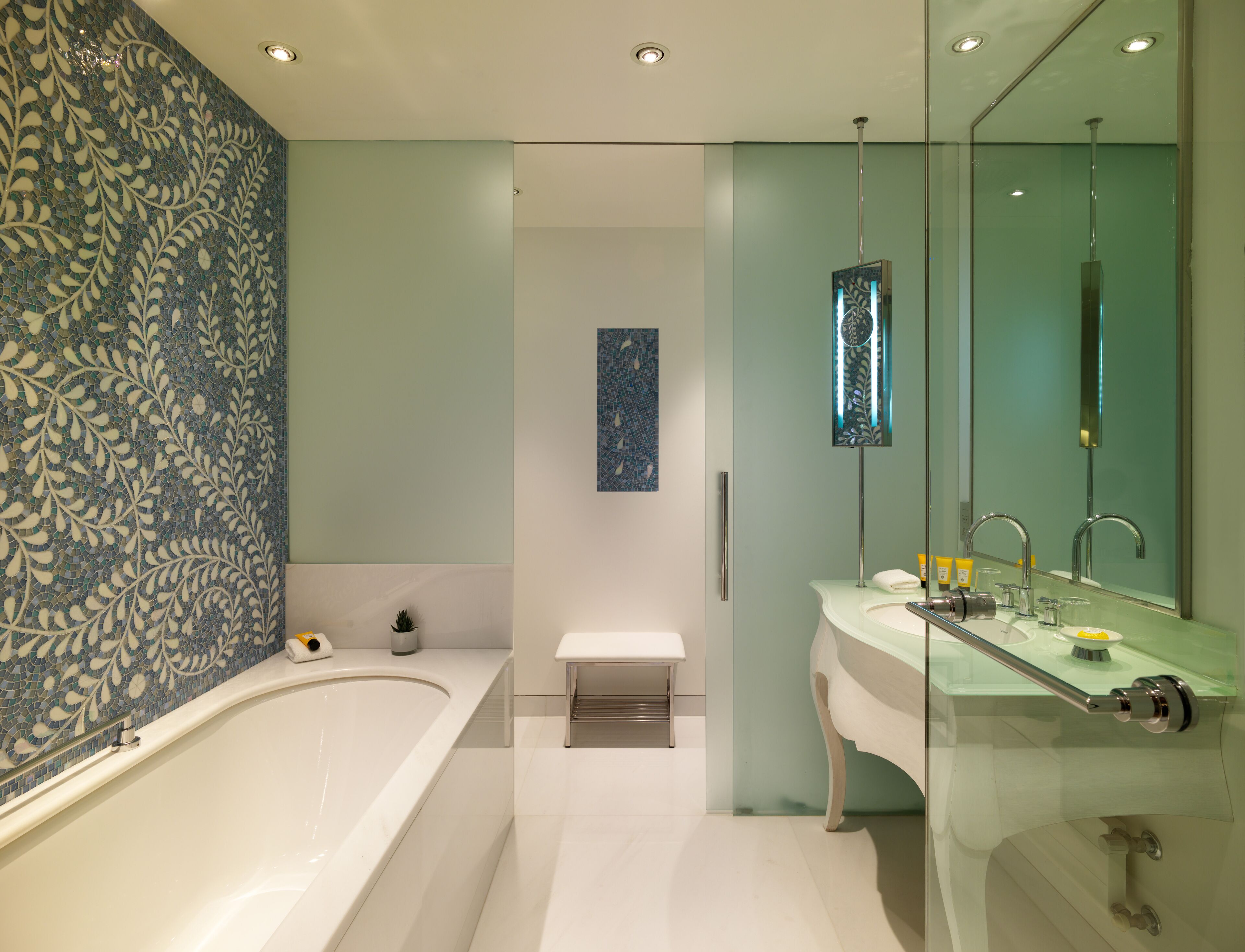 A modern bathroom with a large bathtub, a glass-enclosed shower, and a vanity with a mirror.