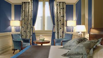 Ein Hotelzimmer mit einem Bett, zwei Sesseln, einem kleinen Tisch und zwei Lampen.