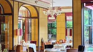 A restaurant with a checkered floor, tables set for dining, and a chandelier. - Hotel Principe Di Savoia (Milan)