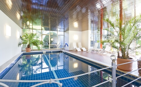 Una piscina techada, sillones reclinables de piscina. Wittelsbacher Hof Swiss Quality Hotel