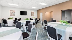 A conference room with multiple tables and chairs, a flat-screen TV mounted on the wall, and framed artwork on the walls. - Comfort Inn Pocono Lakes Region (Lake Ariel)
